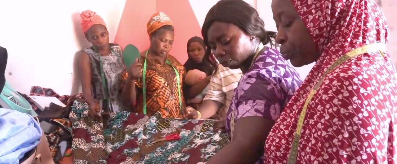 Fashion students cutting Ankara fabric together in a tailoring class